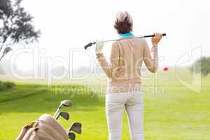 Lady golfer holding her club behind her head