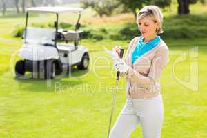 Cheerful golfer standing on the putting green