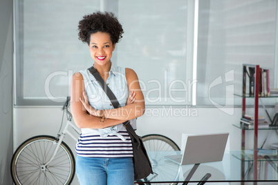 Portrait of casual young woman standing with arms crossed