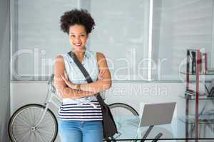 Portrait of casual young woman standing with arms crossed