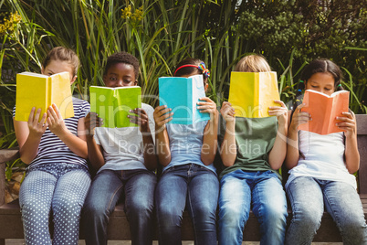 Children reading books at park