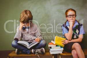 Kids with stack of books in classroom