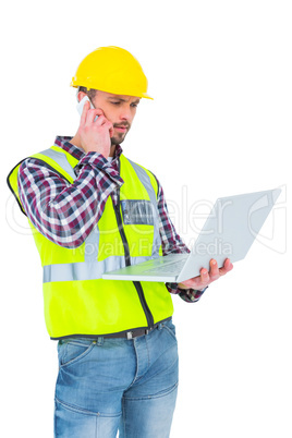 Handyman on the phone holding laptop
