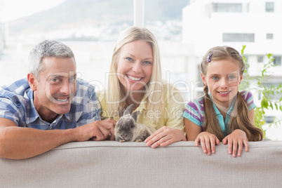 Happy family with rabbit on sofa at home