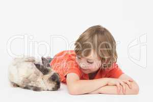 Cute boy lying down while looking at bunny
