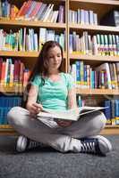 Student sitting on floor in library reading