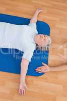 Senior woman lying on exercise mat