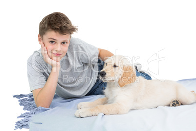 Boy with dog lying on blanket