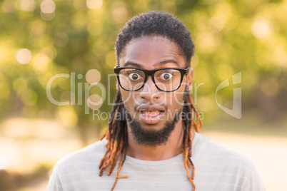 Handsome hipster looking surprised in park