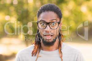 Handsome hipster looking surprised in park