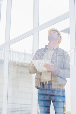 Supervisor looking up while writing on clipboard