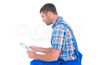 Handyman reading clipboard on white background