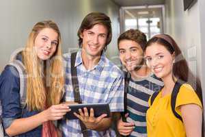 Students using digital tablet at college corridor