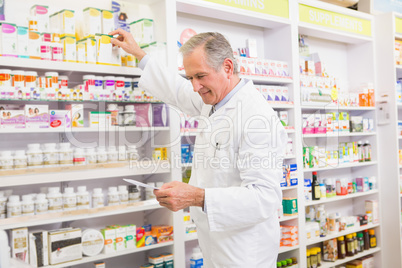 Pharmacist taking medicine from shelf