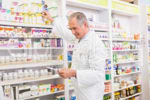 Pharmacist taking medicine from shelf