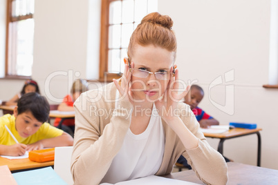 Thinking teacher sitting at desk