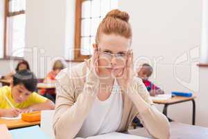 Thinking teacher sitting at desk