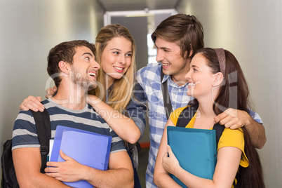 Students holding folders at college corridor