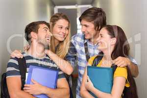 Students holding folders at college corridor