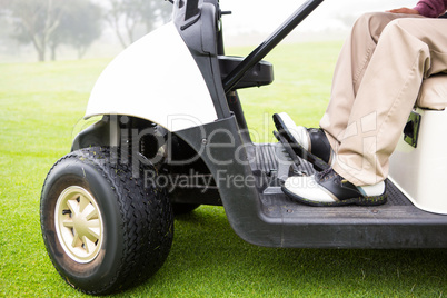 Golfer driving his golf buggy