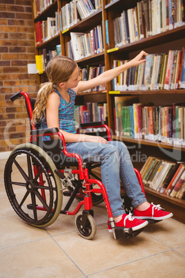 Girl in wheelchair selecting book in library