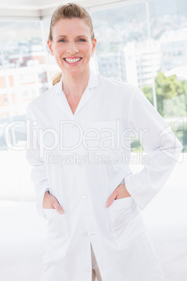 Smiling doctor looking at camera with hands in pockets