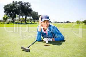 Female golfer looking at her ball on putting green