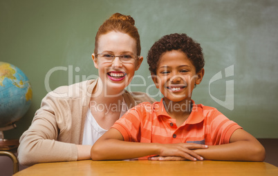 Happy female teacher and boy in classroom