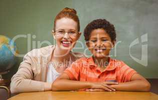 Happy female teacher and boy in classroom