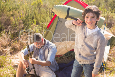 Father and son beside their tent in the countryside