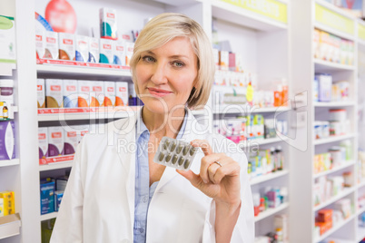 Smiling pharmacist showing blister