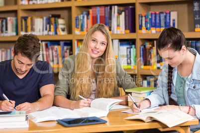 College students doing homework in library