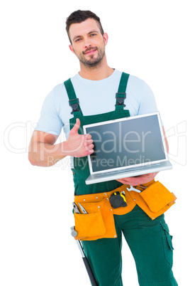 Smiling construction worker holding laptop