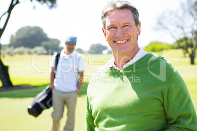 Golfing friends smiling at camera Golfing friends smiling at camera