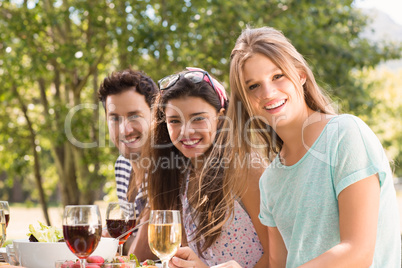 Happy friends in the park having lunch