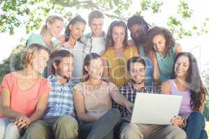 Friends looking at laptop in the park