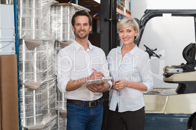 Smiling warehouse managers looking at camera