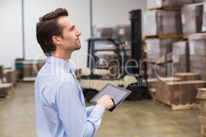 Manager using digital tablet in warehouse