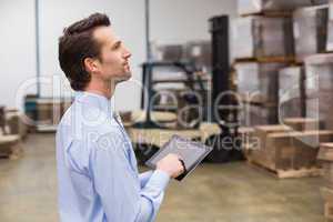 Manager using digital tablet in warehouse