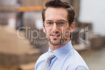 Smiling warehouse manager wearing eyeglasses