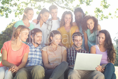 Friends looking at laptop in the park