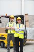 Manager with arms crossed and his colleague behind him