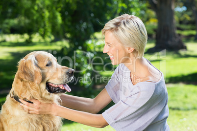 Pretty blonde playing with her dog in the park