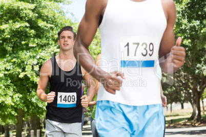 Happy people running race in park