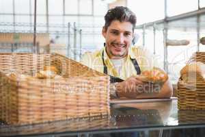 Smiling server in apron holding bread