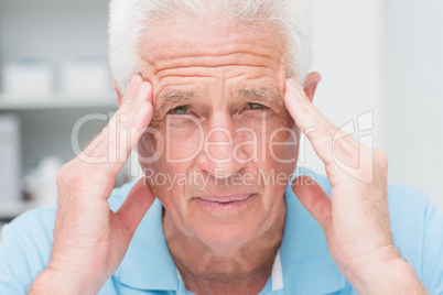 Portrait of senior male patient suffering from headache
