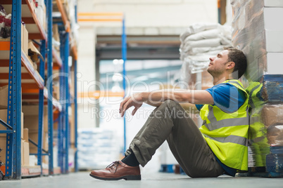 Tired manual worker sitting on floor