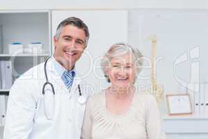 Happy male doctor and female patient in clinic