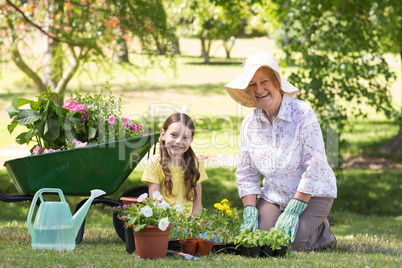 Happy grandmother with her granddaughter gardening