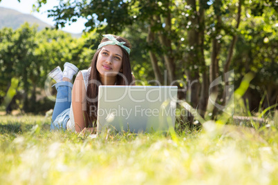 Pretty brunette using laptop in park